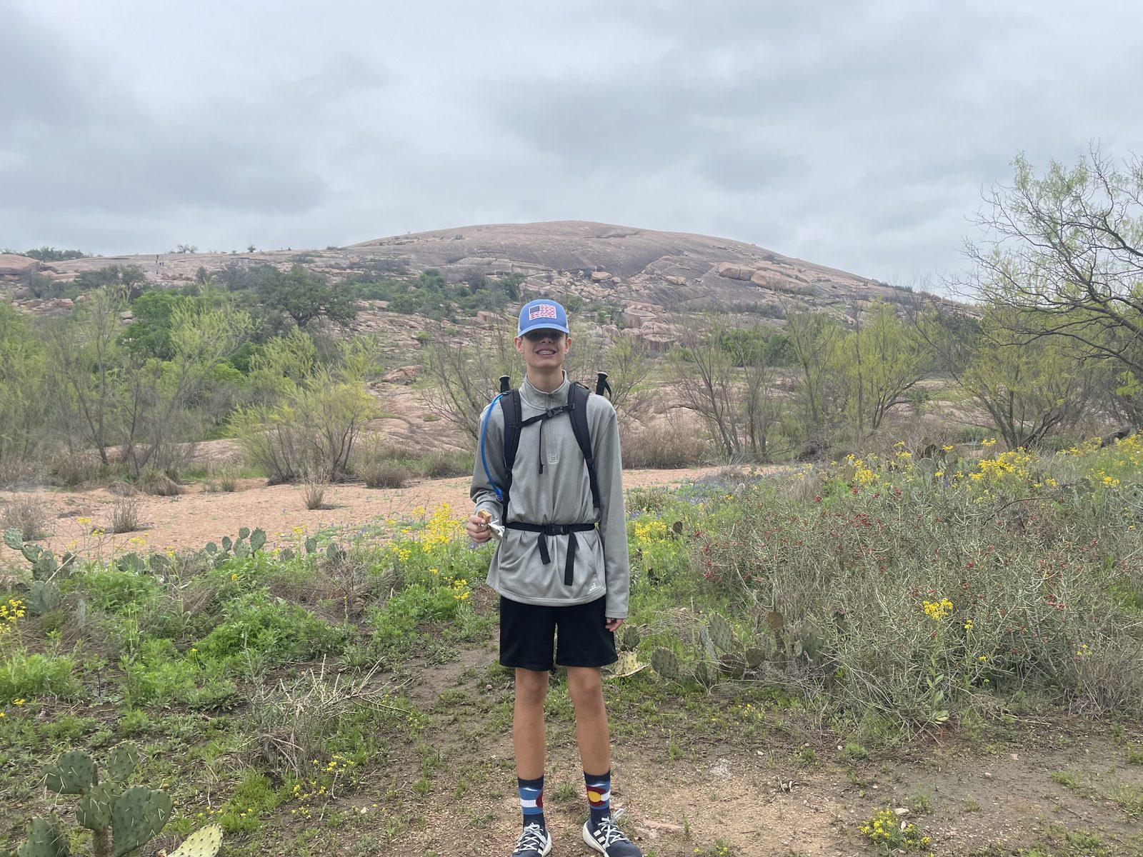 A Trailman hiking up the bare granite face of Enchanted Rock